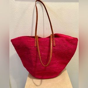 Fusia basket weave bag with leather handles.